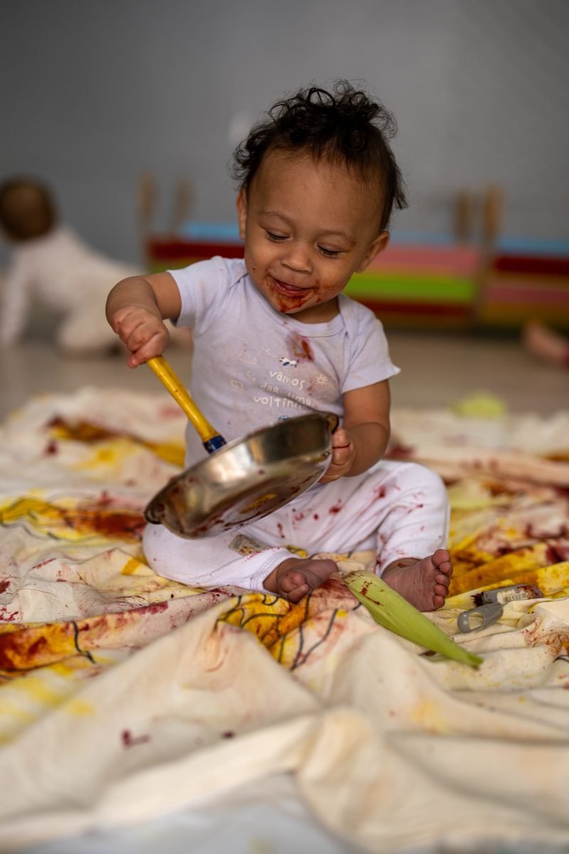 Bebê brincando com panela em atividade sensorial