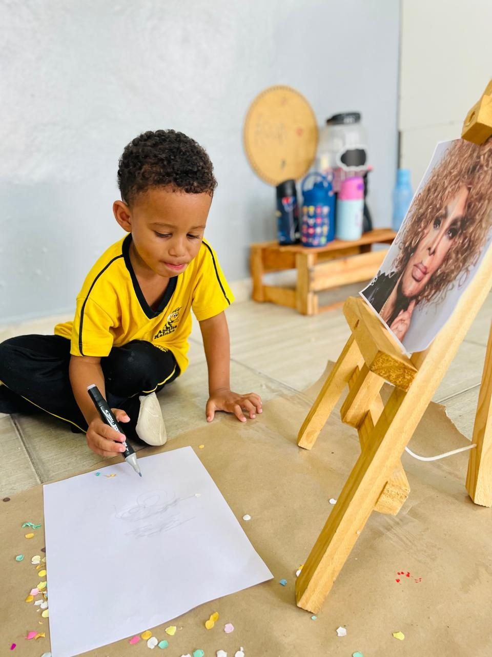 Criança desenhando no cavalete